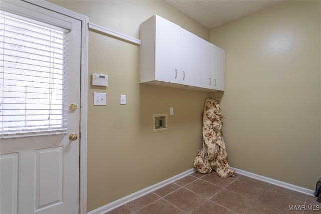 clothes washing area with cabinets, hookup for a washing machine, dark tile patterned flooring, and a healthy amount of sunlight