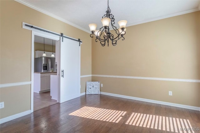 unfurnished room featuring a barn door, crown molding, dark hardwood / wood-style floors, and a notable chandelier