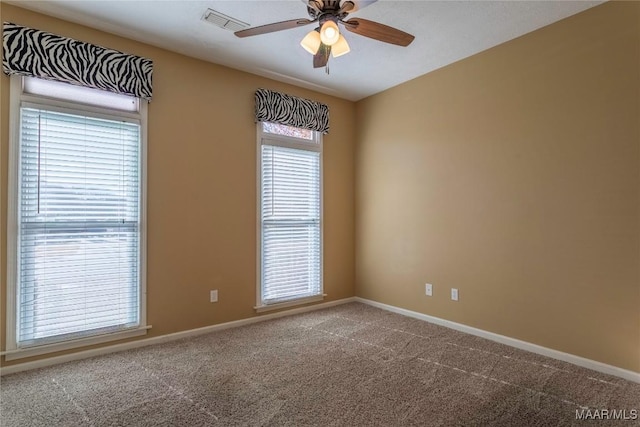 empty room featuring ceiling fan, carpet floors, and a healthy amount of sunlight