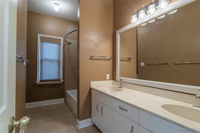 bathroom featuring tile patterned floors, vanity, a textured ceiling, and tiled shower / bath