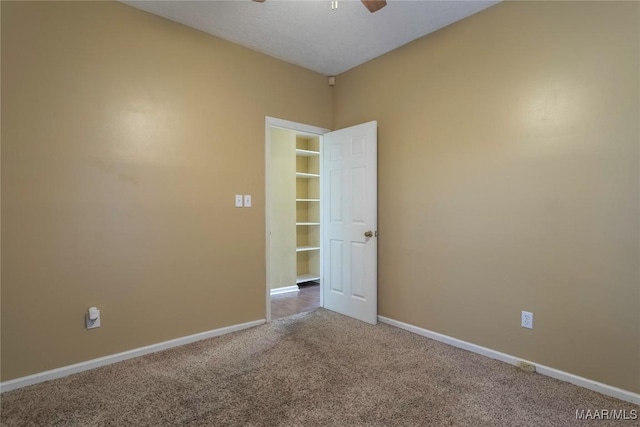 carpeted spare room featuring ceiling fan and a textured ceiling