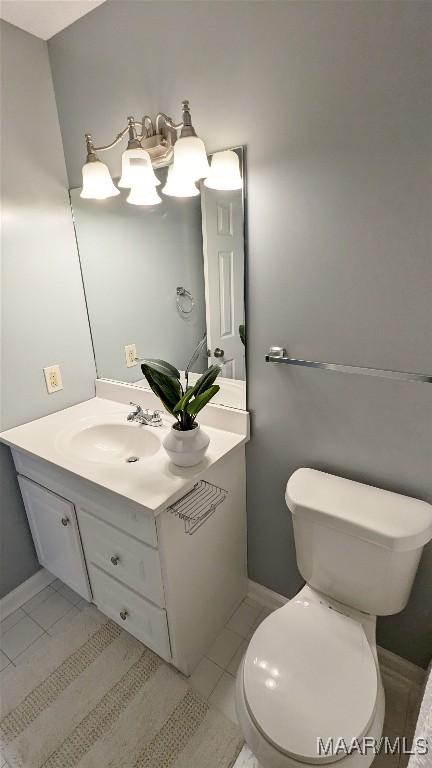 bathroom with tile patterned flooring, vanity, and toilet