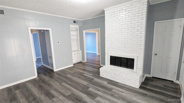 unfurnished living room with a textured ceiling, a brick fireplace, dark wood-type flooring, and crown molding