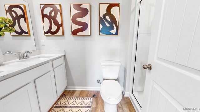 bathroom with toilet, vanity, and hardwood / wood-style flooring