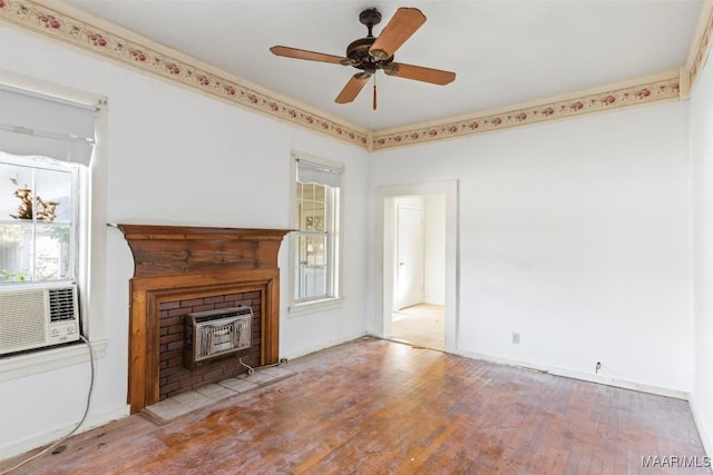 unfurnished living room featuring a wood stove, ceiling fan, heating unit, cooling unit, and light wood-type flooring