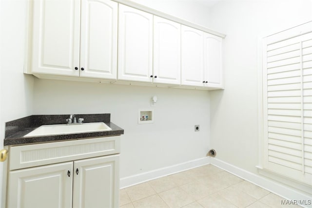 laundry area with electric dryer hookup, cabinets, sink, hookup for a washing machine, and light tile patterned floors