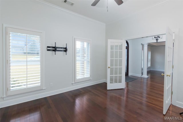 unfurnished room featuring decorative columns, a wealth of natural light, french doors, and dark wood-type flooring