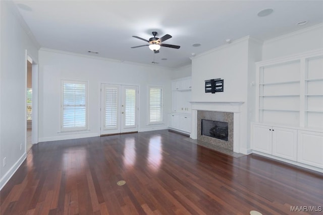 unfurnished living room featuring dark hardwood / wood-style flooring, built in features, ceiling fan, and ornamental molding