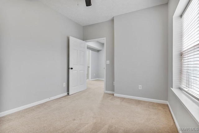 carpeted empty room featuring ceiling fan and a textured ceiling