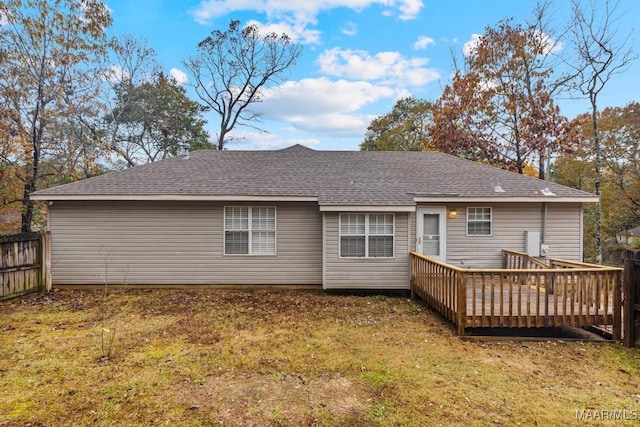 rear view of house featuring a wooden deck and a yard