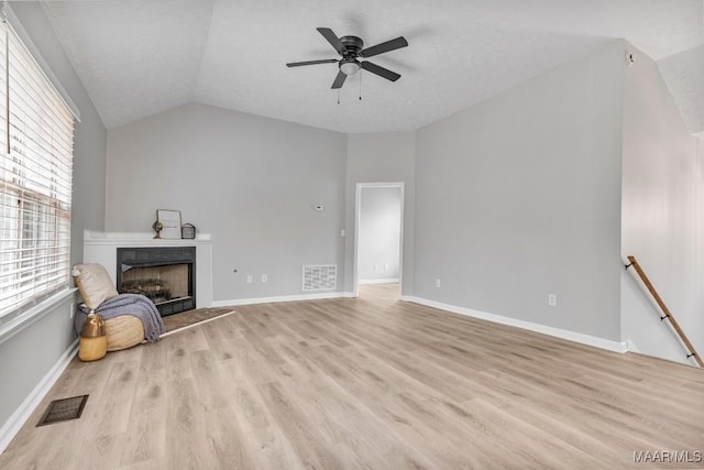 unfurnished living room with a textured ceiling, ceiling fan, light hardwood / wood-style flooring, and lofted ceiling