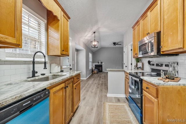 kitchen featuring appliances with stainless steel finishes, backsplash, vaulted ceiling, ceiling fan, and sink