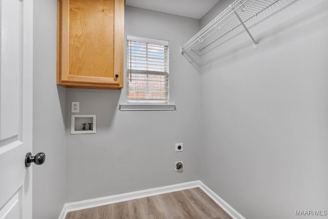 laundry room with cabinets, hookup for a washing machine, light hardwood / wood-style flooring, and electric dryer hookup