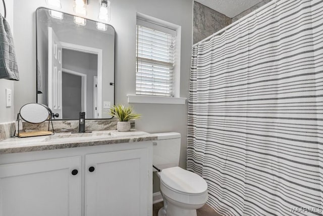 bathroom featuring vanity, a shower with shower curtain, a textured ceiling, and toilet