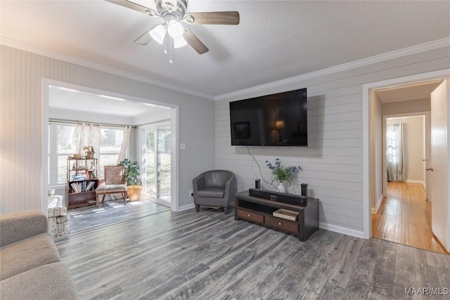 living room with wood-type flooring, a textured ceiling, ceiling fan, and ornamental molding