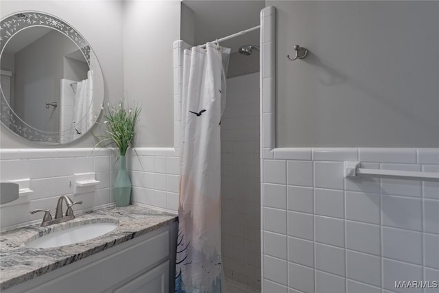 bathroom with vanity, walk in shower, and tile walls