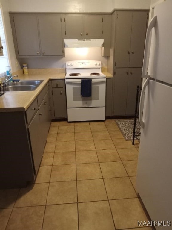 kitchen with light tile patterned flooring, white appliances, gray cabinets, and sink