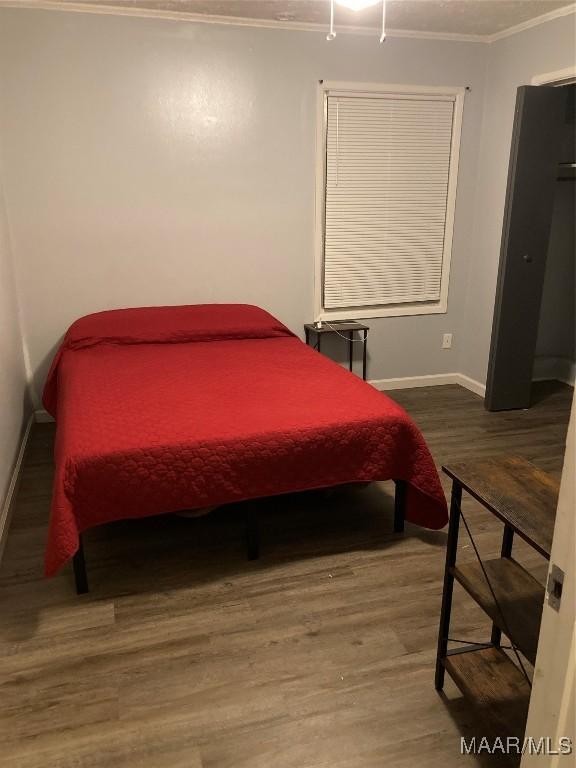 bedroom featuring hardwood / wood-style flooring and ornamental molding