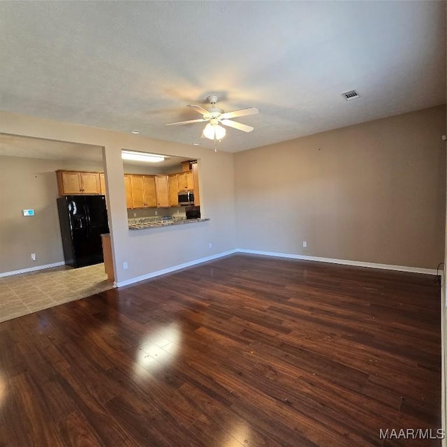 unfurnished living room featuring dark hardwood / wood-style floors and ceiling fan