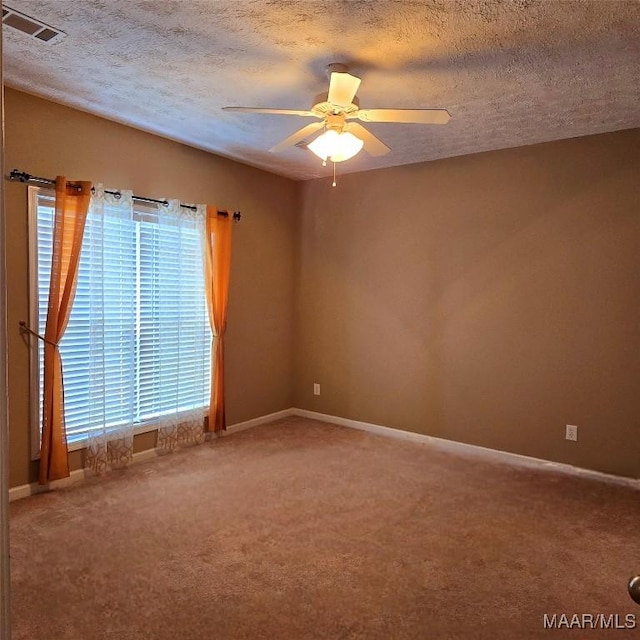 carpeted empty room featuring ceiling fan and a textured ceiling