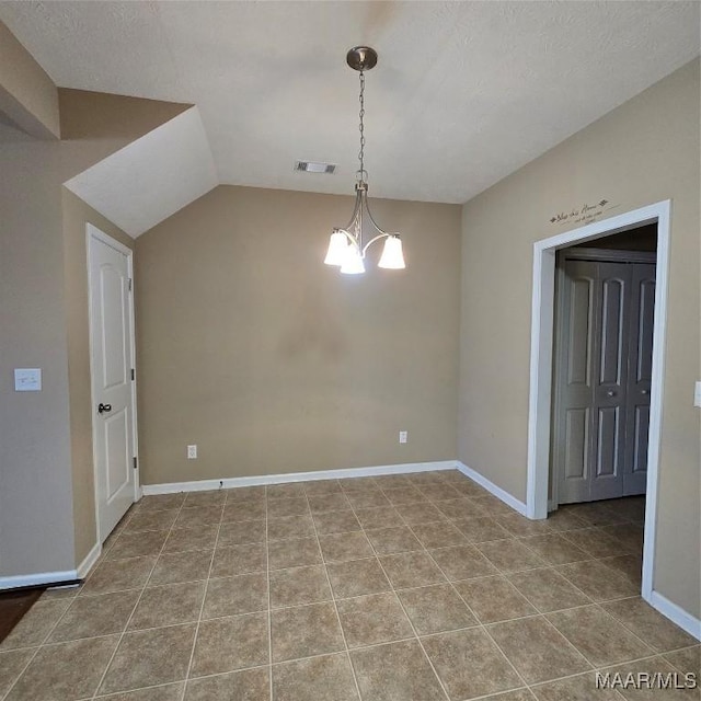 spare room featuring tile patterned floors, a textured ceiling, a chandelier, and vaulted ceiling