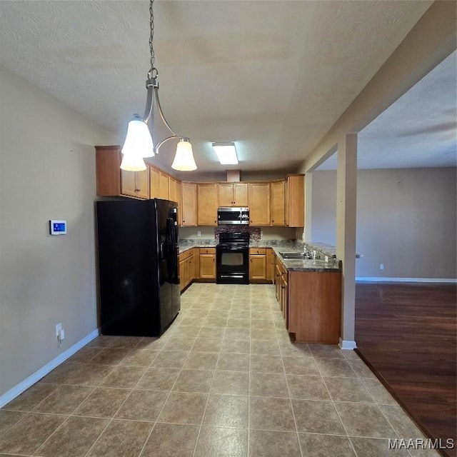 kitchen featuring light hardwood / wood-style flooring, dark stone counters, a textured ceiling, decorative light fixtures, and black appliances