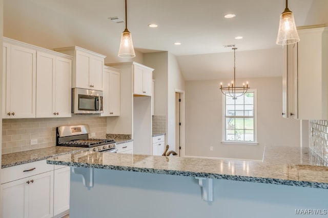 kitchen featuring visible vents, white cabinets, appliances with stainless steel finishes, backsplash, and light stone countertops