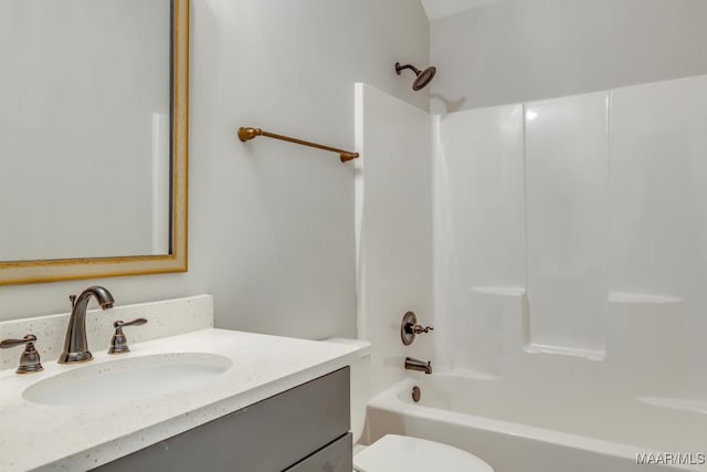 bathroom featuring washtub / shower combination, vanity, and toilet