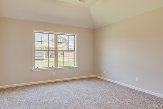 carpeted empty room with vaulted ceiling, visible vents, and baseboards