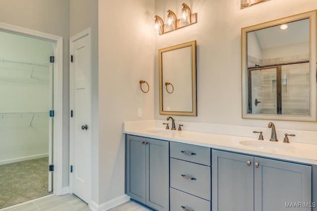 full bath featuring double vanity, an enclosed shower, a spacious closet, and a sink