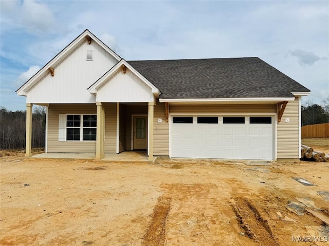 view of front of home with concrete driveway, an attached garage, and roof with shingles