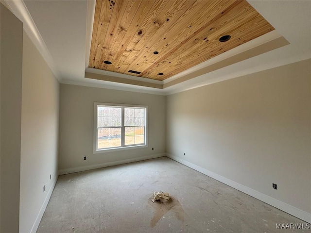 spare room featuring a raised ceiling, wood ceiling, baseboards, and ornamental molding