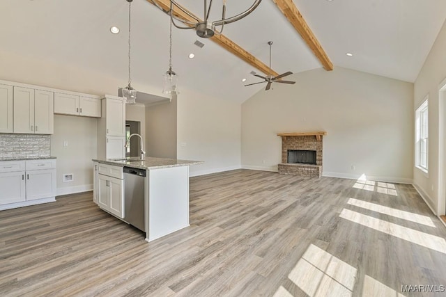 96 Madix Dr, Eclectic, AL 36024 - kitchen with beamed ceiling, ceiling fan, dishwasher, a brick fireplace, and a sink