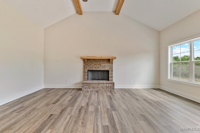 96 Madix Dr, Eclectic, AL 36024 - unfurnished living room featuring beamed ceiling, baseboards, a fireplace, wood finished floors, and high vaulted ceiling