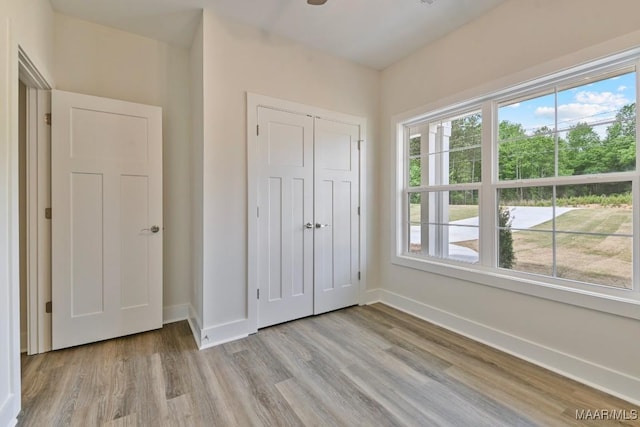 96 Madix Dr, Eclectic, AL 36024 - unfurnished bedroom with baseboards, wood finished floors, multiple windows, and a closet