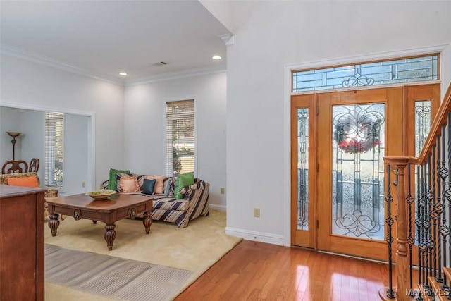 entrance foyer featuring crown molding and light hardwood / wood-style flooring