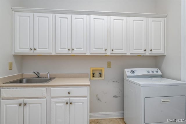 washroom with cabinets, washer / dryer, and sink