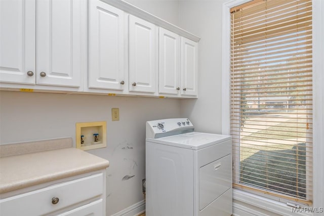 clothes washing area featuring cabinets and washer / dryer