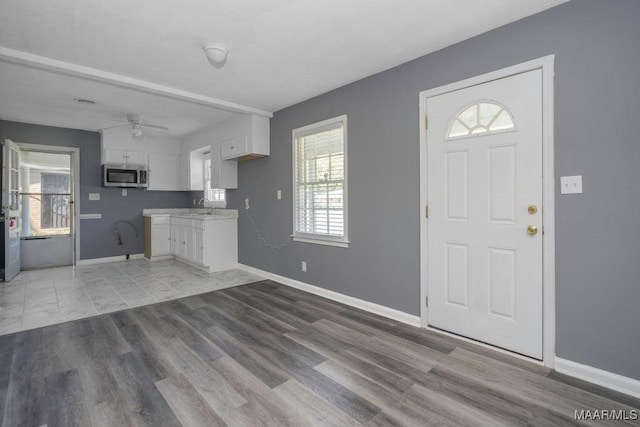 foyer featuring a wealth of natural light, sink, ceiling fan, and light hardwood / wood-style floors