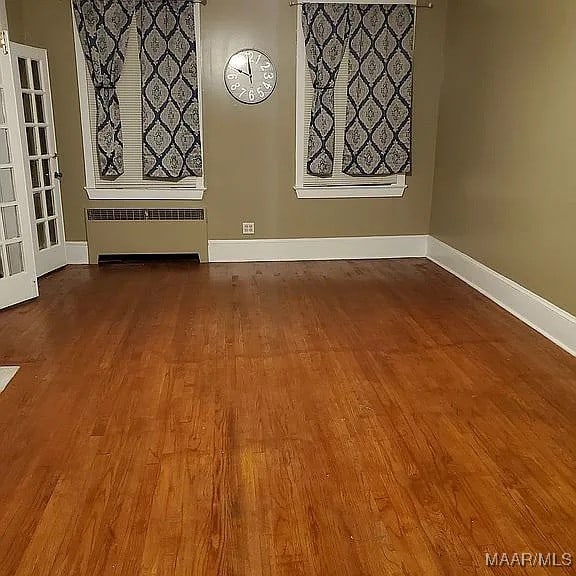 spare room with wood-type flooring and radiator heating unit