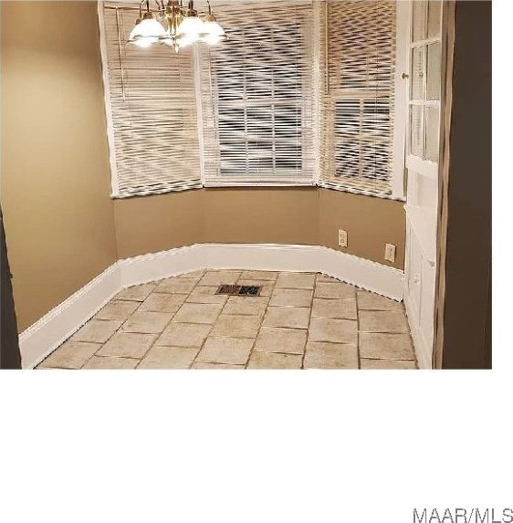 unfurnished dining area with a chandelier