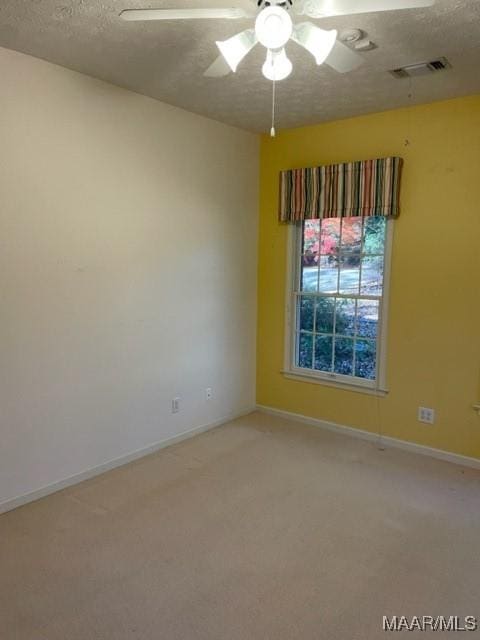 unfurnished room featuring a textured ceiling, light colored carpet, and ceiling fan