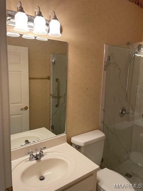 bathroom with vanity, toilet, and an enclosed shower