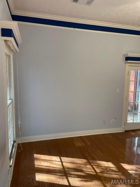 unfurnished room with crown molding and dark wood-type flooring