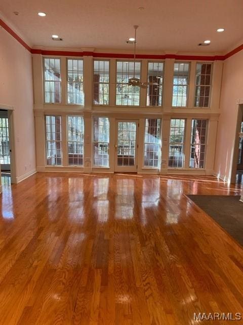 unfurnished living room with hardwood / wood-style floors and ornamental molding