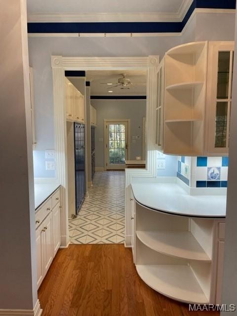 kitchen featuring white cabinetry, light hardwood / wood-style floors, and ornamental molding