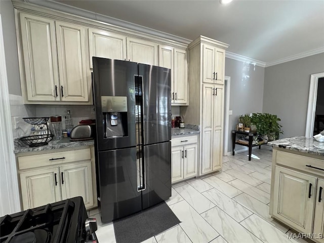 kitchen with refrigerator with ice dispenser, light stone countertops, crown molding, and cream cabinetry