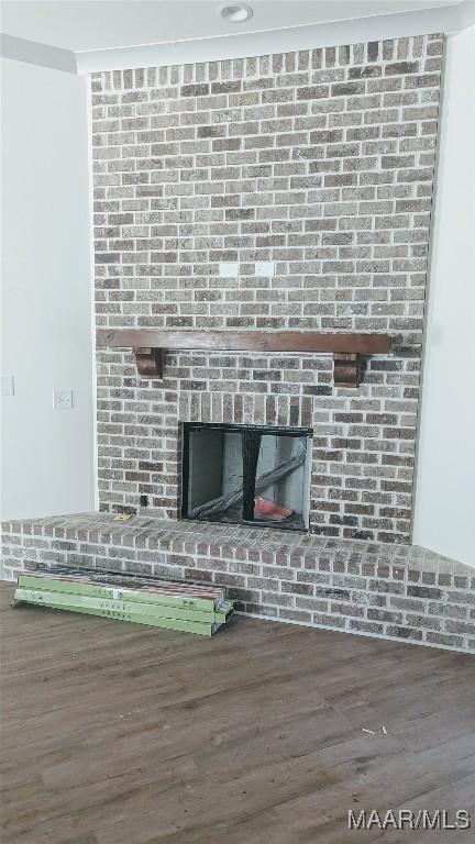 interior details featuring hardwood / wood-style floors and a brick fireplace