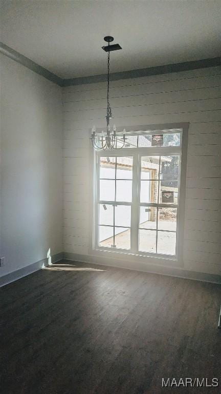 unfurnished dining area with plenty of natural light, carpet floors, and a chandelier