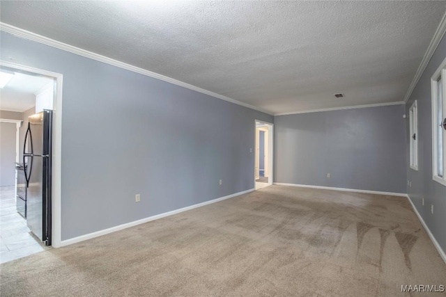 empty room with a textured ceiling, ornamental molding, and light carpet